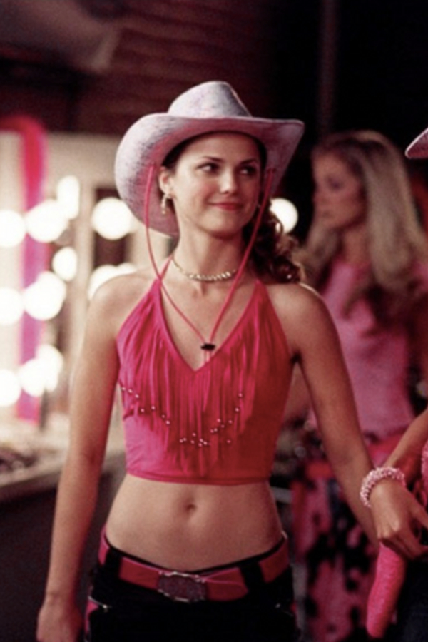 Felicity, looking ridiculous but hot in a cowboy hat, a pink crop tank top, and low-slung jeans