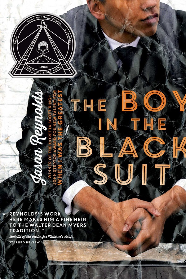 Cover of The Boy in the Black Suit by Jason Reynolds. A Black teen boy in a black suit, shot from the nose down. The picture is crumpled
