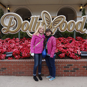 Sarah and Meredith, both wearing pink, standing in front of the Dollywood sign