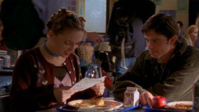 Abby and Chris sit at the lunch table, excitedly looking over a note together
