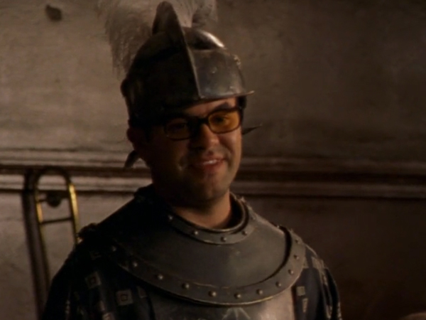 Javier, grinning with his glasses on, wearing a suit of armor and helmet