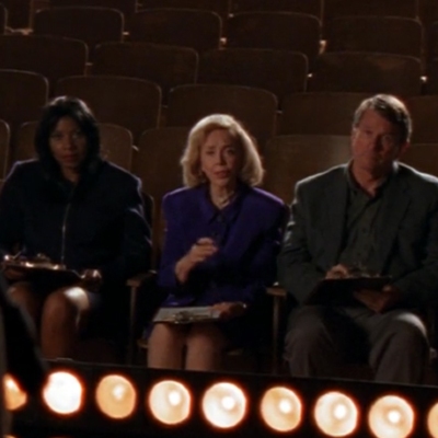 Joyce Brothers, an older well-dressed white woman, sitting in a theater row with two other judges