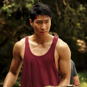 A man in a maroon tank top with nice arms.