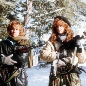 Two female characters from Red Dawn holding guns and wearing camo winter gear.