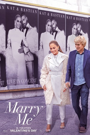 Kat and Charlie walk down the street with giant posters of Kat and Bastian in concert on the wall behind them.