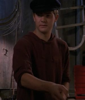 Pacey aboard the True Love in a black captain's hat with a serious look on his face