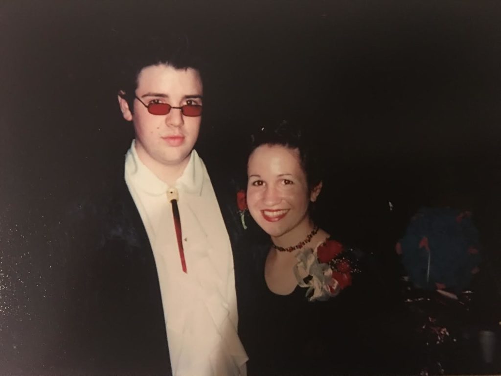 The author and her best friend Jon at their high school prom, both dressed goth. Meredith's look is quite similar to Jen's, and Jon is wearing red-lensed glasses and a bolo tie