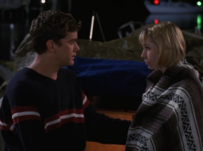 Pacey is comforting a blanket-wrapped Andie on the pier at night