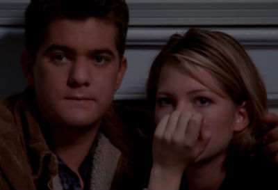 Pacey and Jen sit together, both with big "uh-oh, we're caught" looks on their faces.