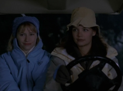 Andie and Joey are in a golf cart, with Joey driving, both of them bundled up for winter, and it's nighttime.