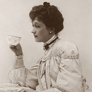 A Victorian-era woman drinks from a tea cup and looks bored.