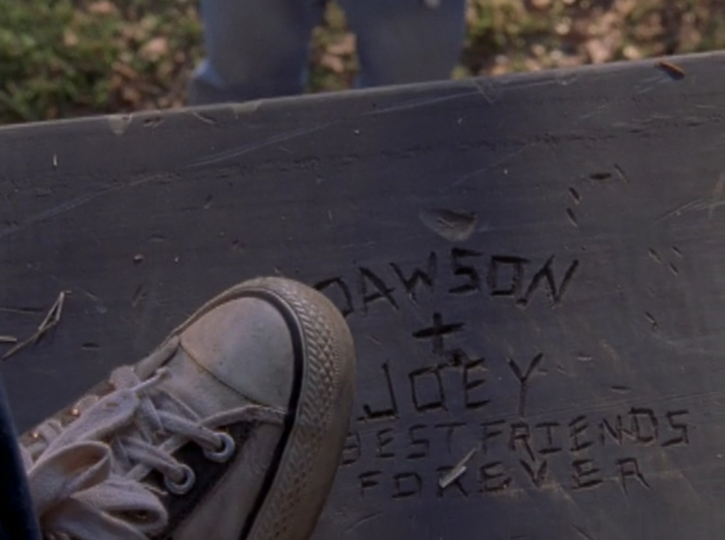 Joey's sneaker hovers over a carving on the barn floor that reads "Dawson + Joey Best Friends Forever"