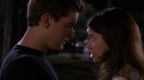 Pacey and Joey stare at each other intently, outside at night.