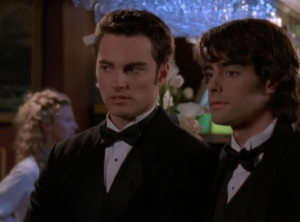 Jack and Ethan stand side-by-side at prom, both looking handsome and uncomfortable in tuxes.
