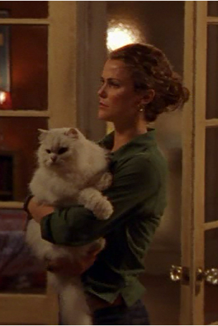 Felicity, holding a big white cat and looking forlorn