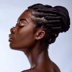 Side profile of Black woman, with hair braided and in a bun