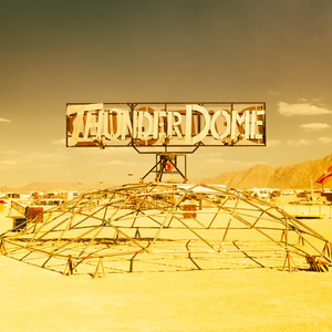 A desert with a open metal cage structure and the word THUNDERDOME on top of it.