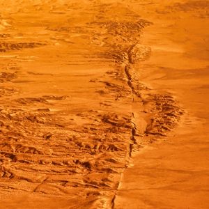 Fault lines on a dry, sandy landscape