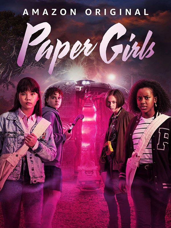 The paper girls stand next to an open time machine glowing pink.
