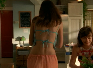 We see Joey's back and she's wearing a coral linen skirt and a turquoise camisole that ties in the back and shows a lot more skin than we're used to seeing on little Joey Potter