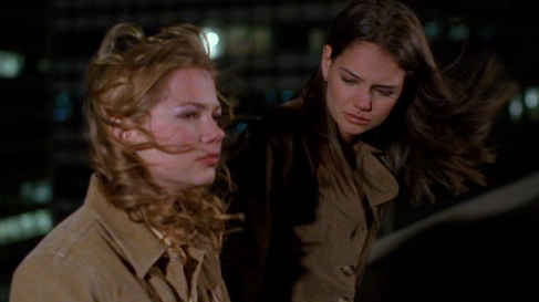 Jen and Joey, on a windy rooftop at night, both with serious looks on their faces