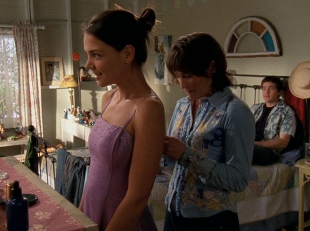 Bessie's standing near Joey in a hideous shirt while Pacey watches from the bed in a hideous shirt