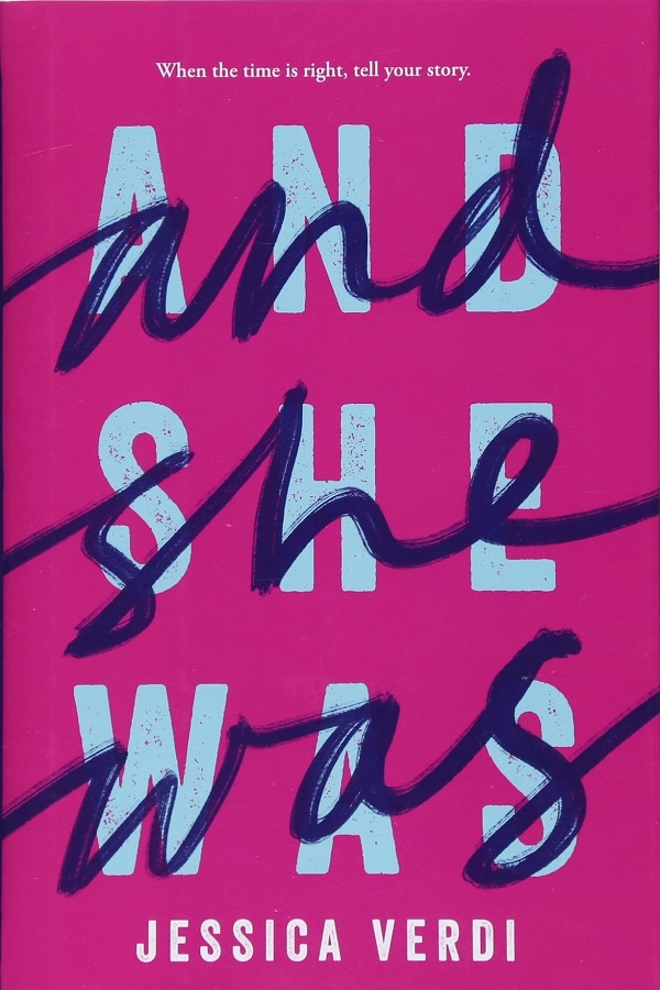 Cover of Jessica Verdi's And She Was. A pink cover with the title in blue block letters, overwritten with the same words in black cursive.