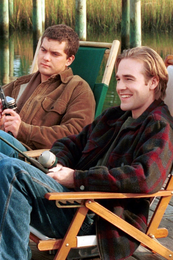 Pacey and Dawson sit on a pier, fishing. Dawson's grinning while Pacey looks more serious