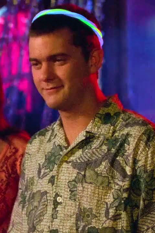 Pacey's at the rave, wearing a glow necklace like a crown with a sardonic look on his face