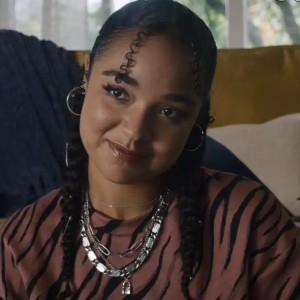 Aisha Dee, a pretty Black young woman with a pleasant expression on her face