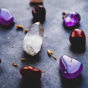 An assortment of gems: a clear crystal, purple stones and shiny red stones