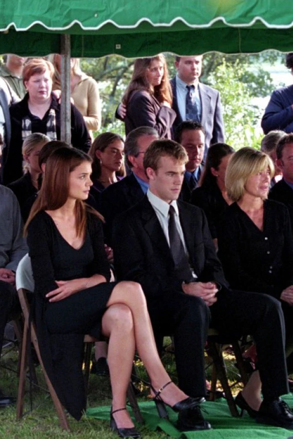 Joey, Dawson and Gail sit, all in black, at Mitch's funeral. Joey and Dawson look devastated but stoic, and Gail is crying