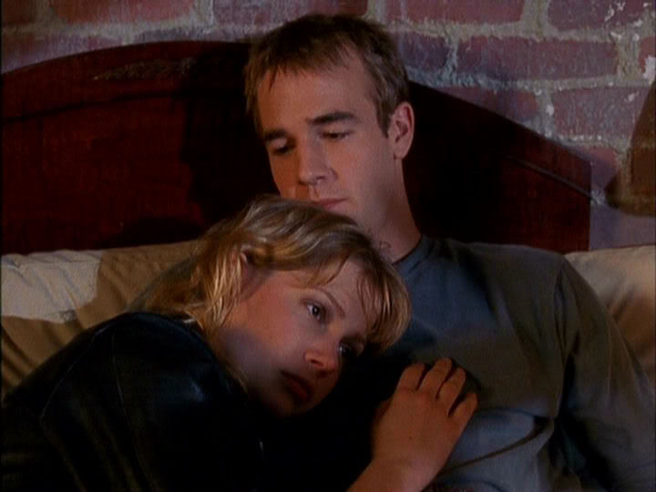 Jen and Dawson lie in bed with Jen's head resting on Dawson's chest, both looking sad