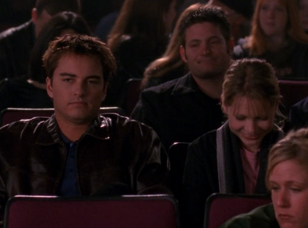 Jack's sitting in the audience of Dawson's movie with awful bleached spiky hair
