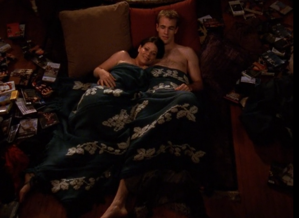 Dawson and Amy Lloyd, cuddled up in bed together, clearly naked under the blanket
