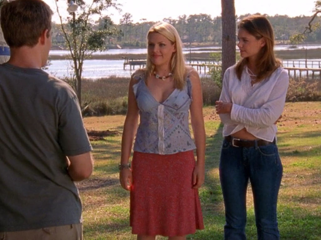 Audrey, in boho chic, standing in sun-dappled Capeside with Joey and Dawson