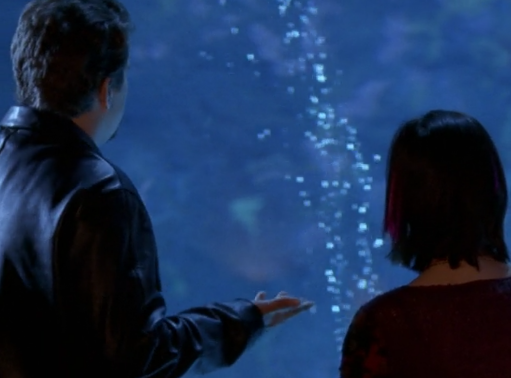 Pacey and Emma stand side by side at the aquarium