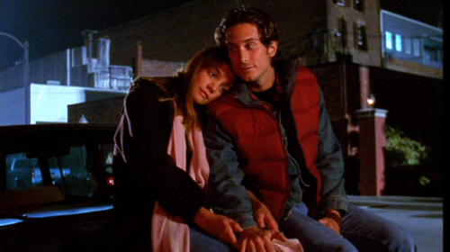 Joey sits next to Eddie on a bench, her head on his shoulder