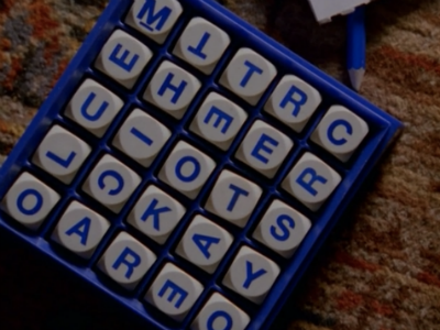 A close-up on a Boggle board (a game from the 2000s with letters on dice pieces that you scramble to find words)