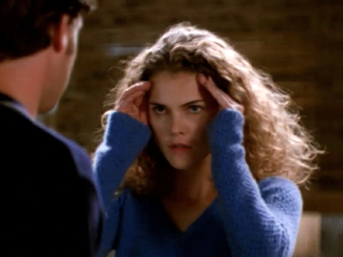 Felicity stares intently at Noel (off-camera), her hands on her forehead like she's concentrating really hard. 