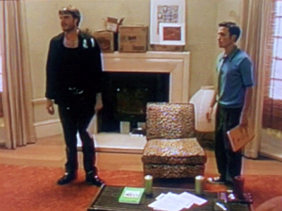 Through Sean's docuventary lens, we see Richard standing next to Noel, who's in terrible leather pants