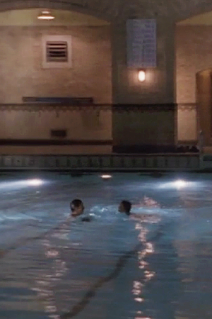 A romantic, faraway shot of Felicity and Ben facing each other in UNY's swimming pool