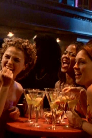 Felicity, Elena and Julie sitting and laughing around a table filled with cocktails