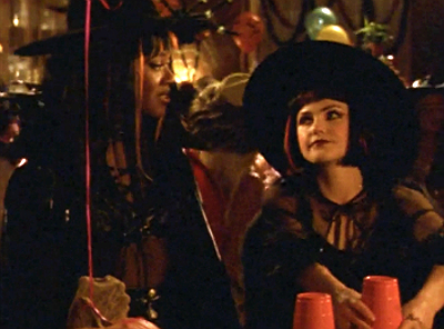Felicity and Elena, dressed as adorable witches with pointy hats and cool wigs, at a costume party