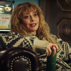 Natasha Lyonne as Charlie, a white woman with wavy blonde hair wearing an amused expression