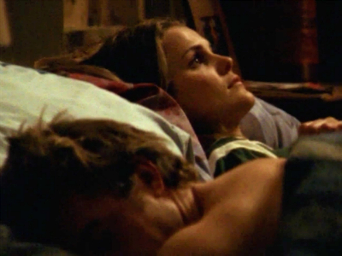 Felicity lies in bed next to Ben. He's asleep and she's staring at the ceiling, looking worried.