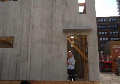 Sarah, peaking out from an open door of a concrete box-shaped building