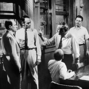 A black and white scene from the movie 12 Angry Men in which men are debating