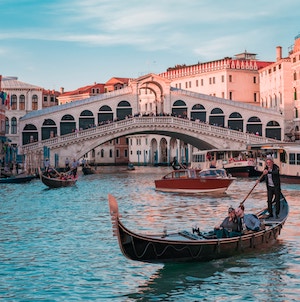 A gondola in a canal in front of a bridge in the city of Venice, Italy