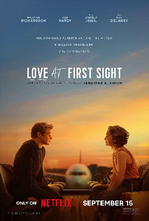 Poster for Love at First Sight, with a blonde white boy sitting across from a white girl with brown curly hair with an airplane in the background